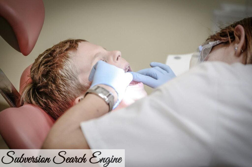 A young boy receiving a dental examination by a professional dentist in a clinic setting.