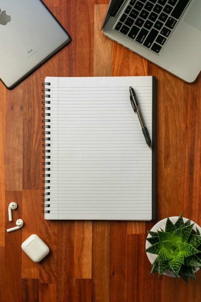 Bolígrafo negro sobre un cuaderno blanco abierto